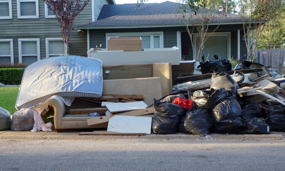 piles of junk in front of home to be hauled away by Doers Junk Removal